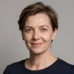 Портрет уверенного российского бизнесмена с дружелюбным взглядом на нейтральном размытом фоне студии